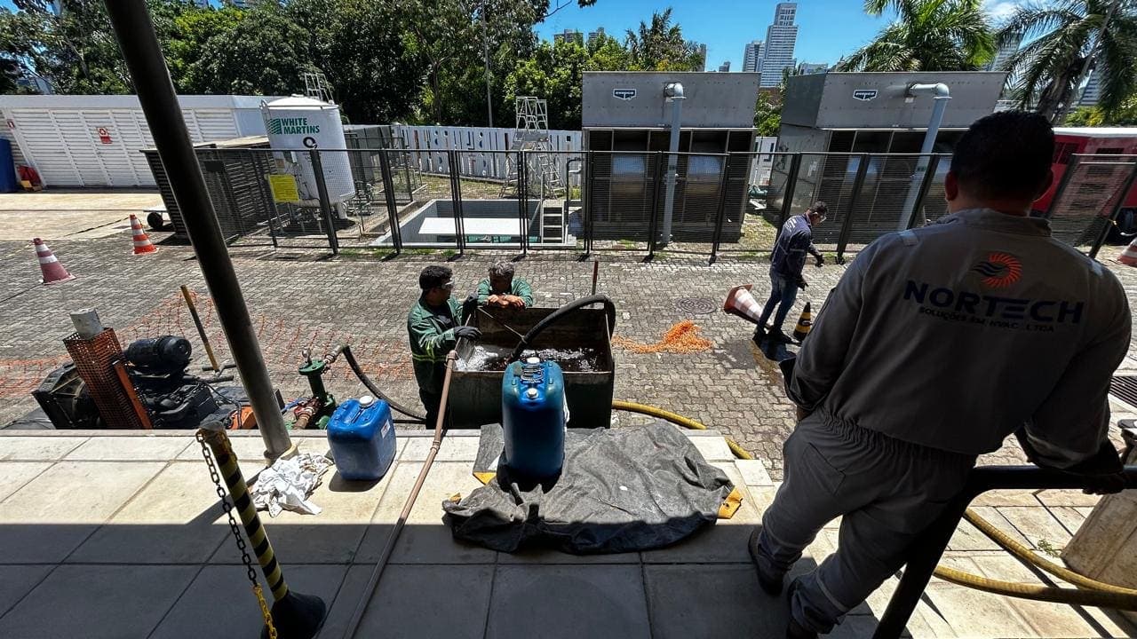 Profissional realizando medições em condensadora